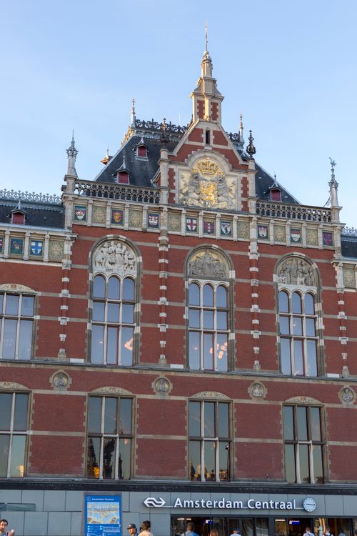 Free Front view of Amsterdam Centraal Station showcasing its historical architectural design. Stock Photo