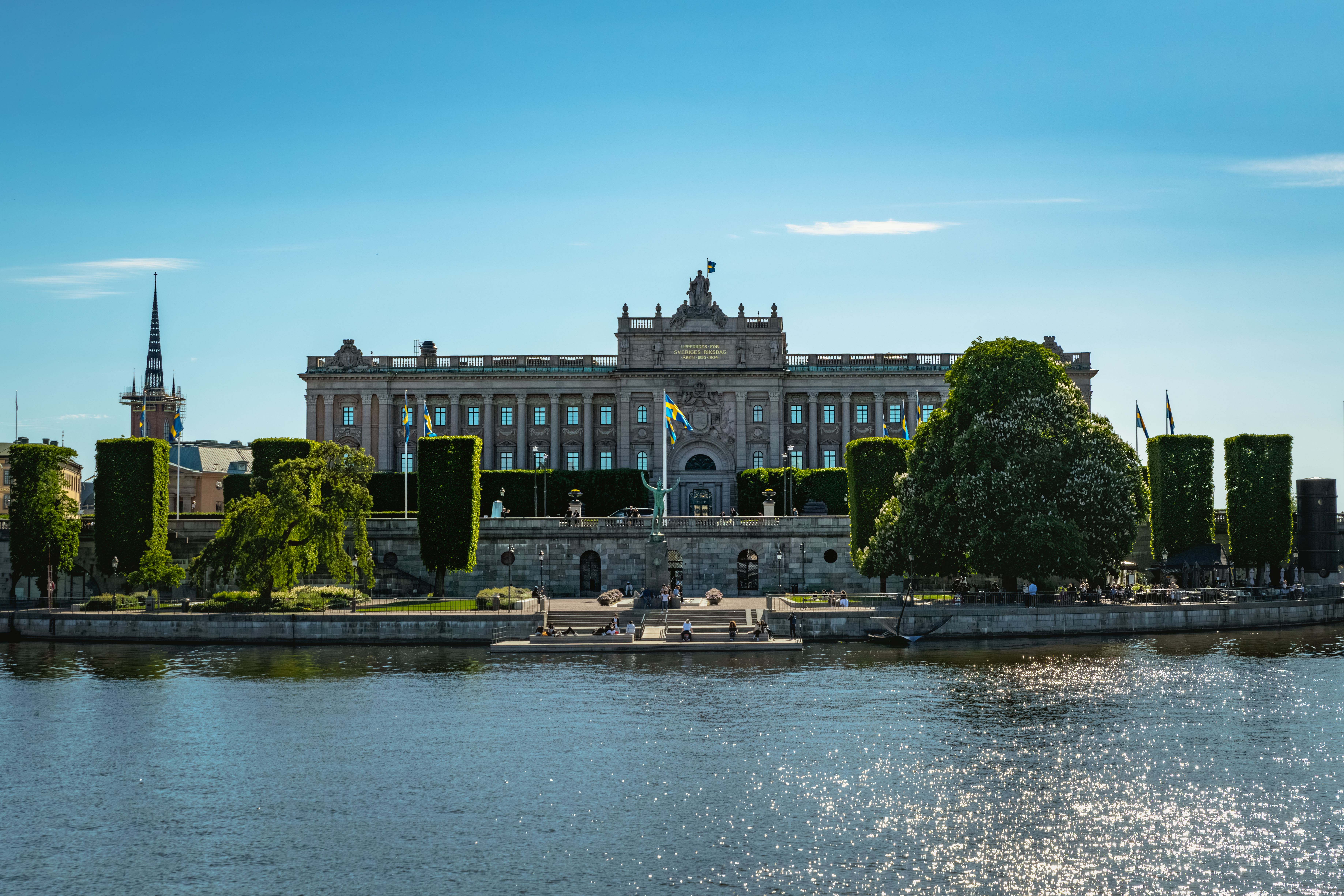 The Riksdag building in Stockholm, Sweden, viewed from across the water on a sunny day.