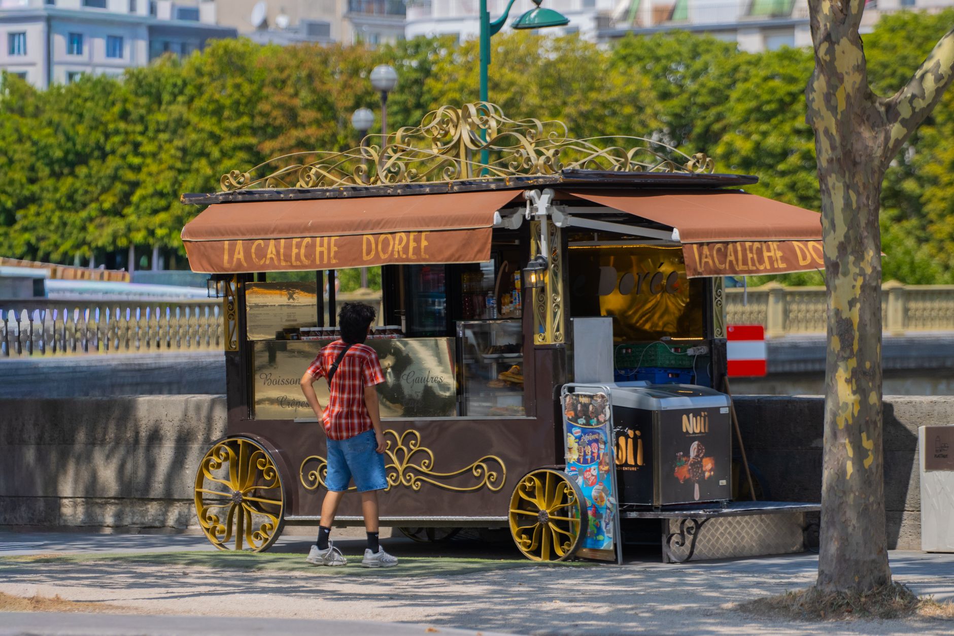 A Parisian street food cart parked near the Seine River