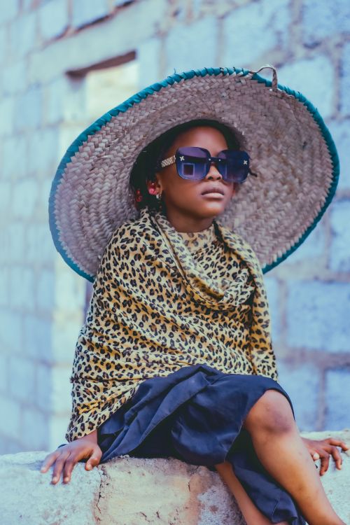 Free Young girl in vibrant outfit and sunglasses posing outdoors in Abuja, Nigeria. Stock Photo