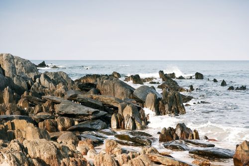Free Stunning rocky shoreline with ocean waves crashing. Perfect for nature backdrops. Stock Photo