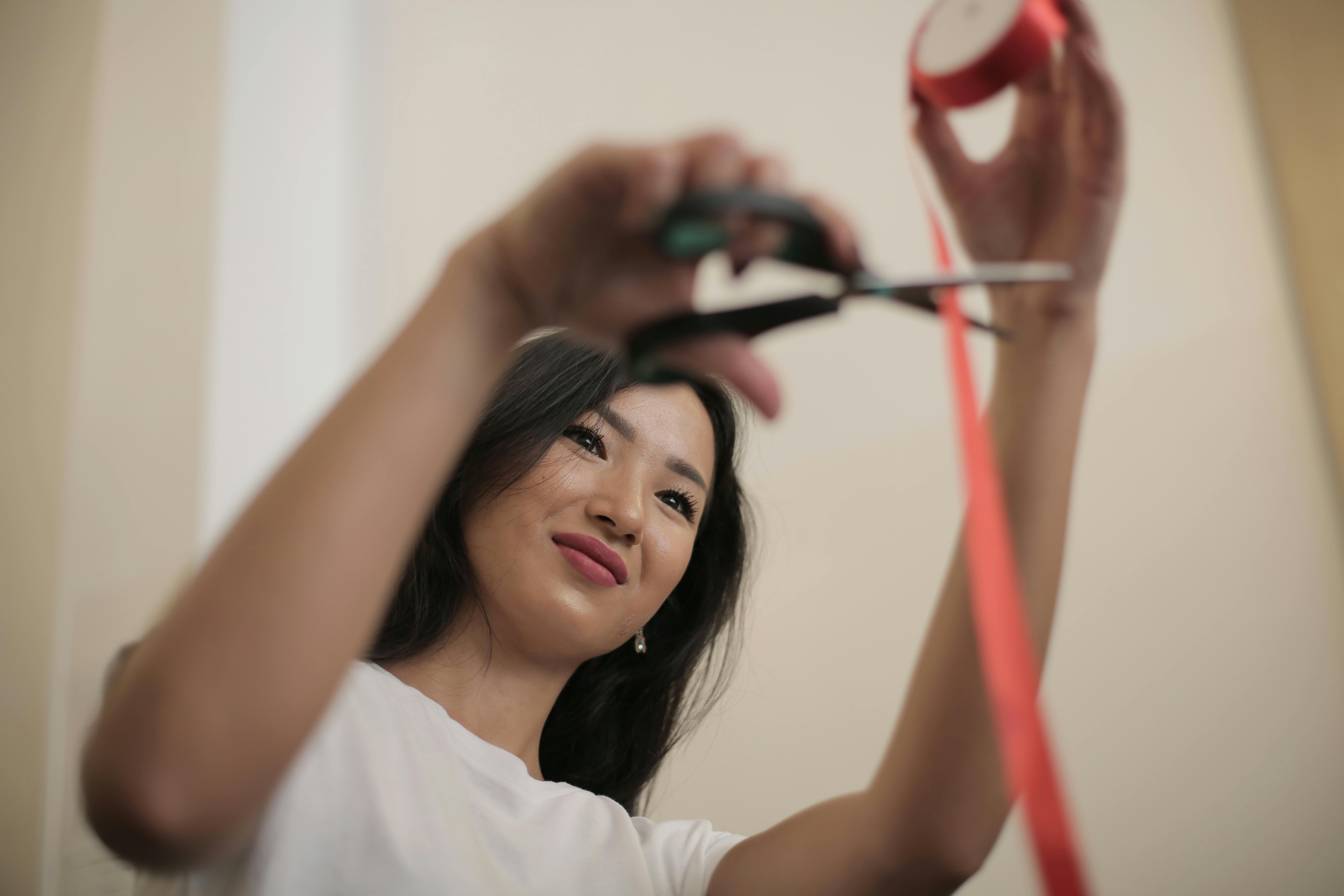 asian woman cutting red tape