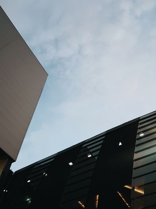 Free From below of high geometric buildings located in city downtown against overcast sky Stock Photo