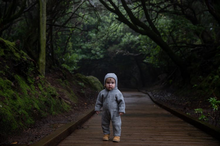 Small Kid Standing On Planked Footpath