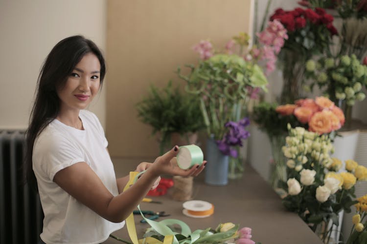 Positive Ethnic Businesswoman With Colorful Silk Tapes At Own Floral Shop