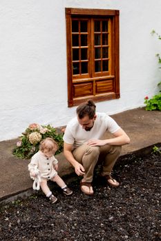 父亲和幼儿在古色古香的小屋外共度美好时光