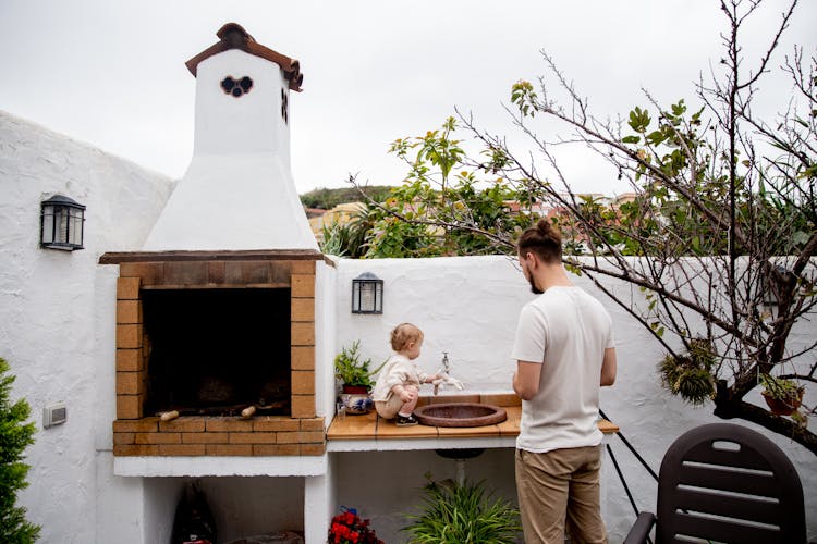 Young Father With Adorable Little Child Near Outdoor Kitchen