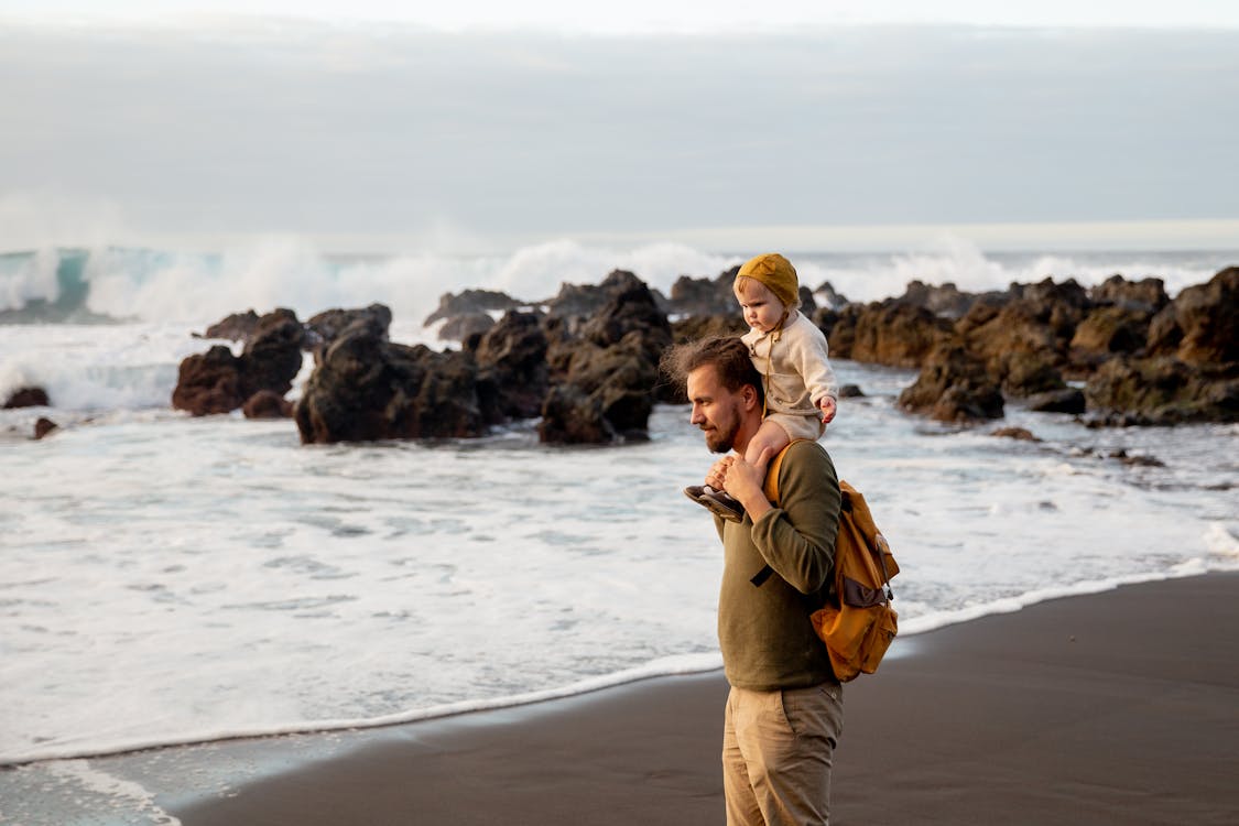 Father And Child Standing on Seashore