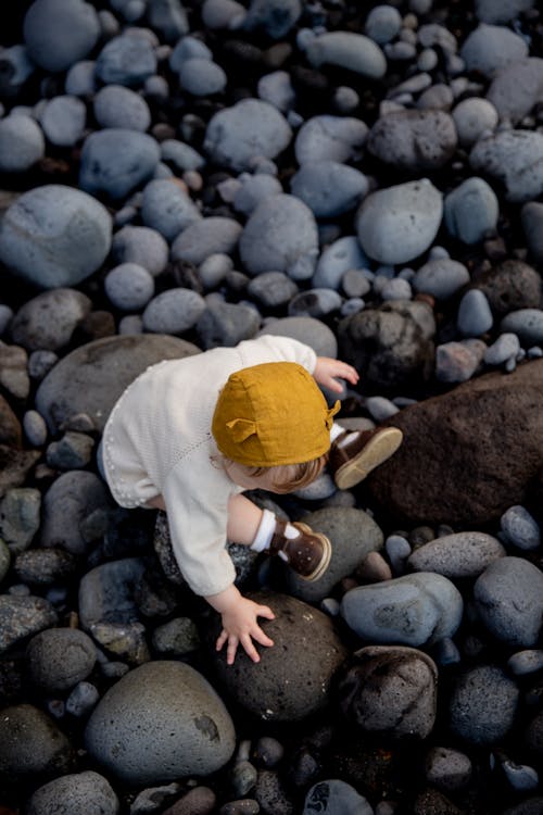 A Baby Sitting On Rocks