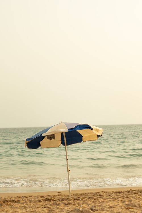 Free Serene beach with a solitary umbrella against the Moroccan coast. Stock Photo