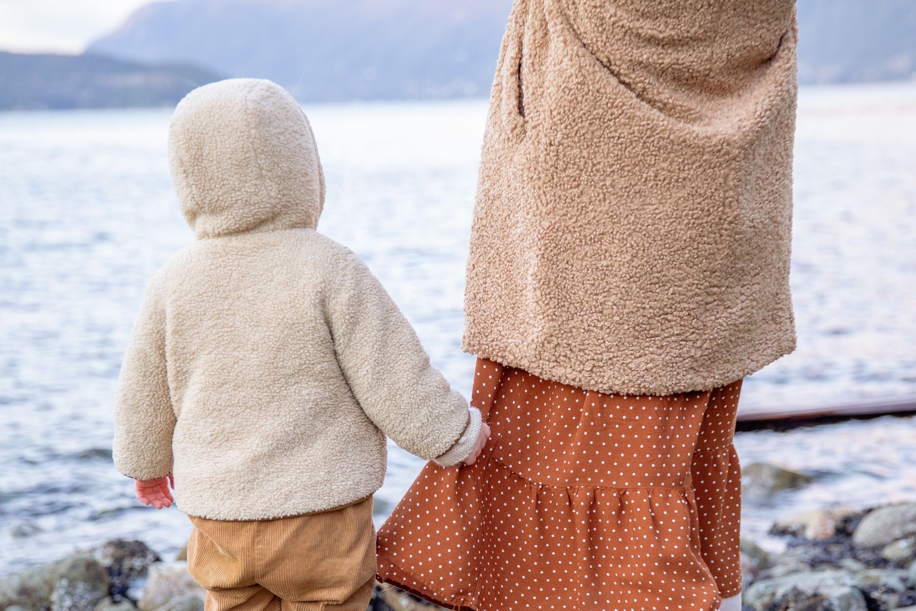 冬服の母親と子どもが並んで歩く後ろ姿