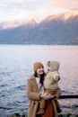 日落时分，母亲和幼儿在山间湖边共享温暖时刻