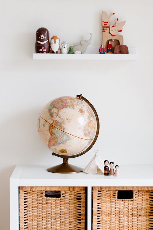 Retro toys and globe on cabinet in nursery room