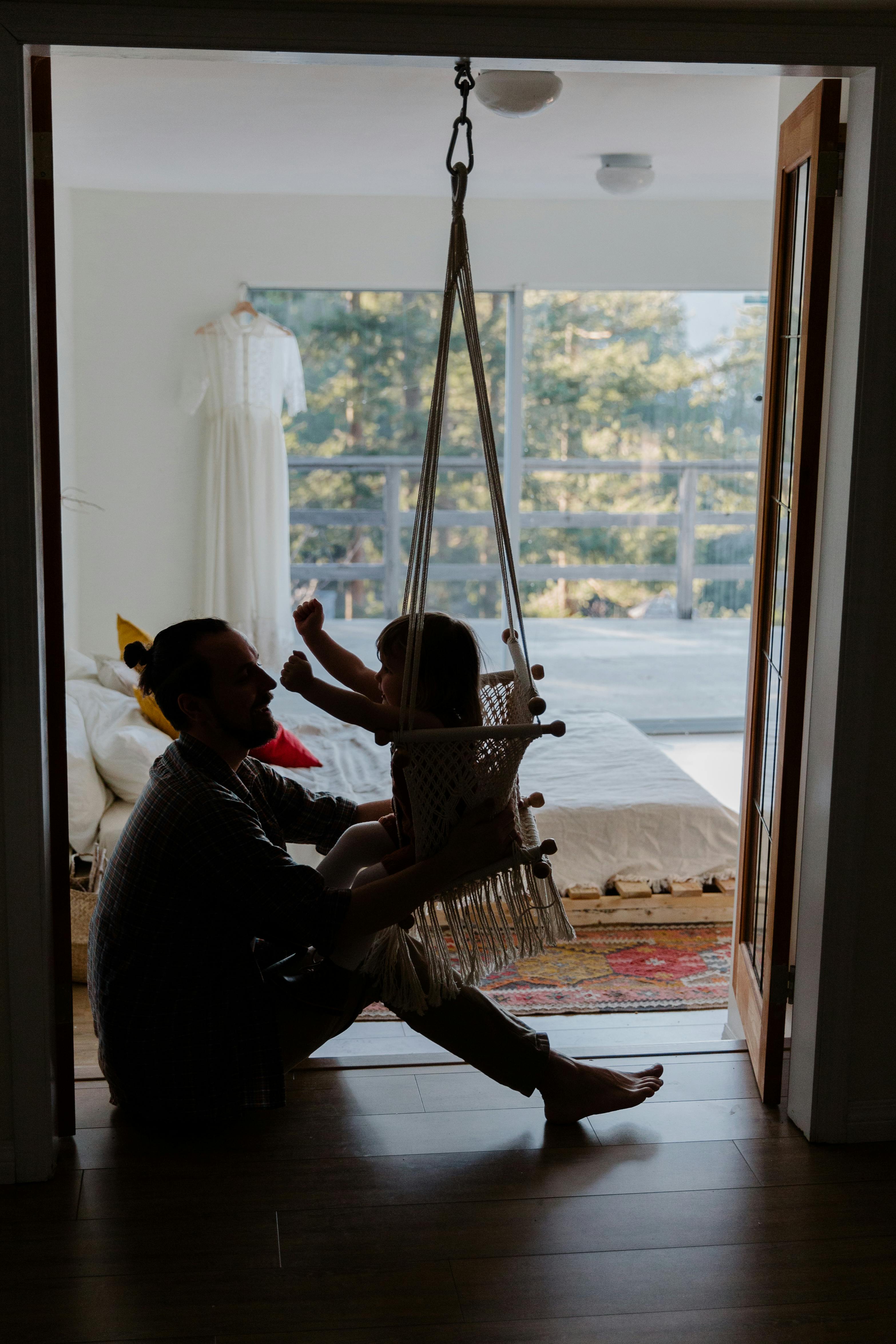 father playing with daughter on floor in cozy room