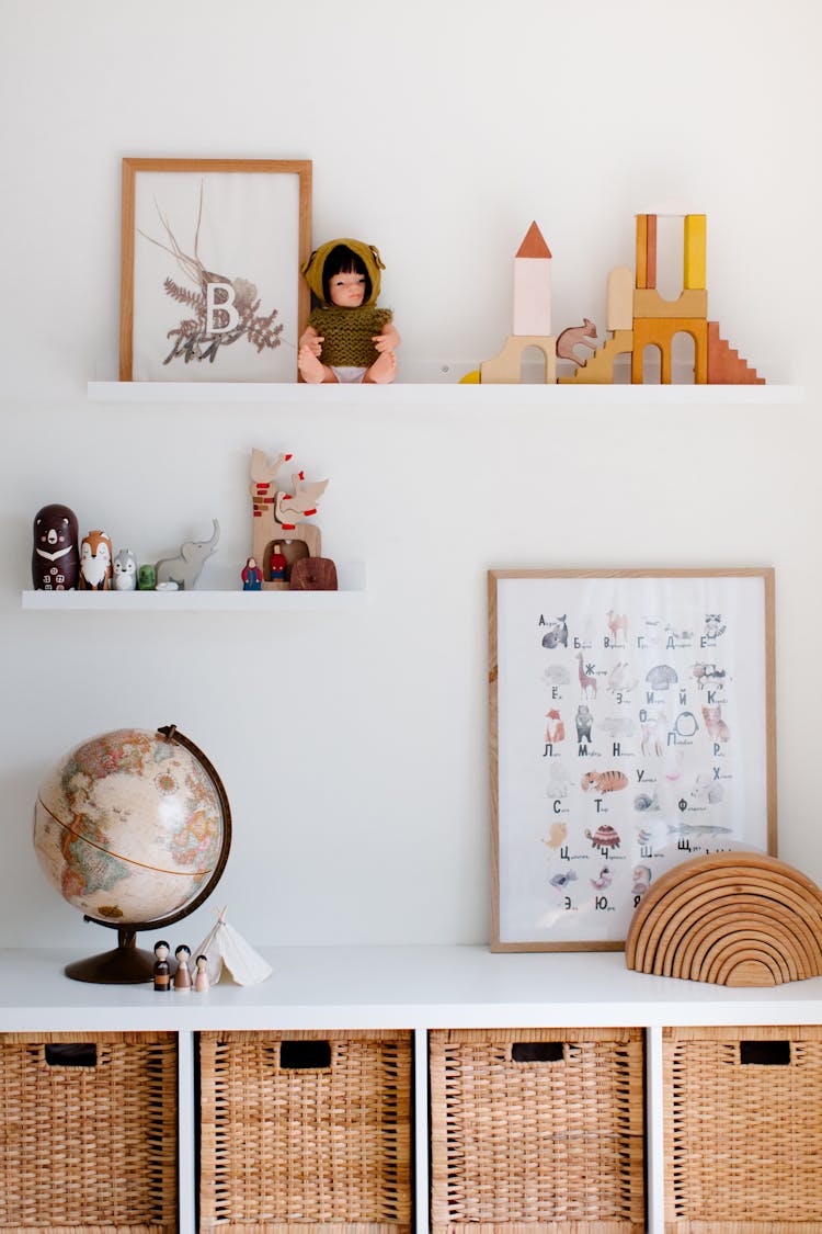 Vintage Glove On Cabinet With Toys And Paintings On Shelves At Home