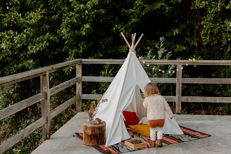 Little Kid Coming In Wigwam On Terrace