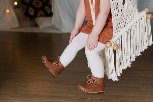 Crop little girl swinging on swing