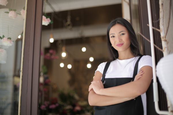 A home bakery owner at the entrance of her shop.