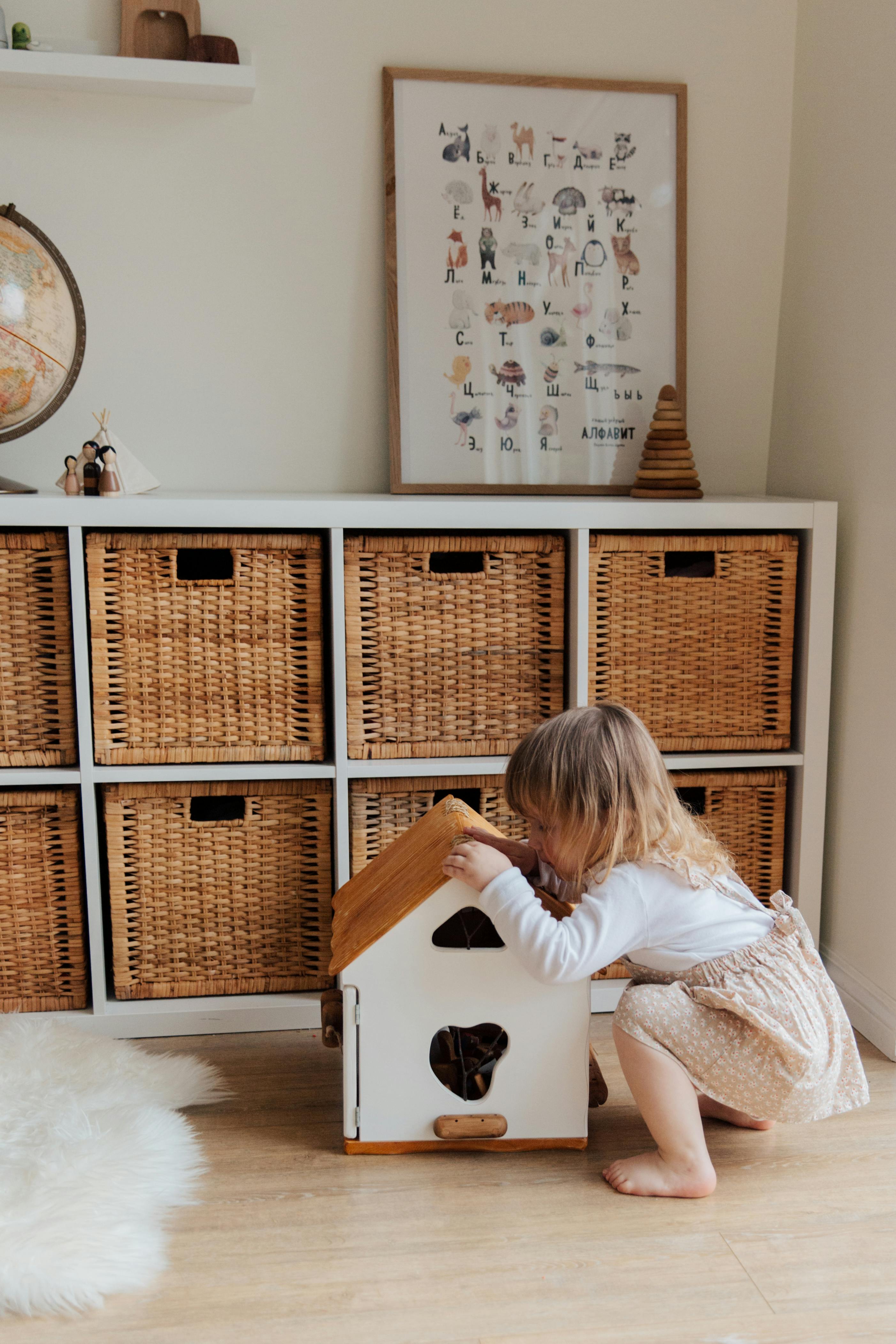 girl playing with a wooden toy house