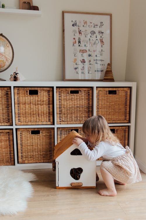 Free Girl Playing With A Wooden Toy House Stock Photo