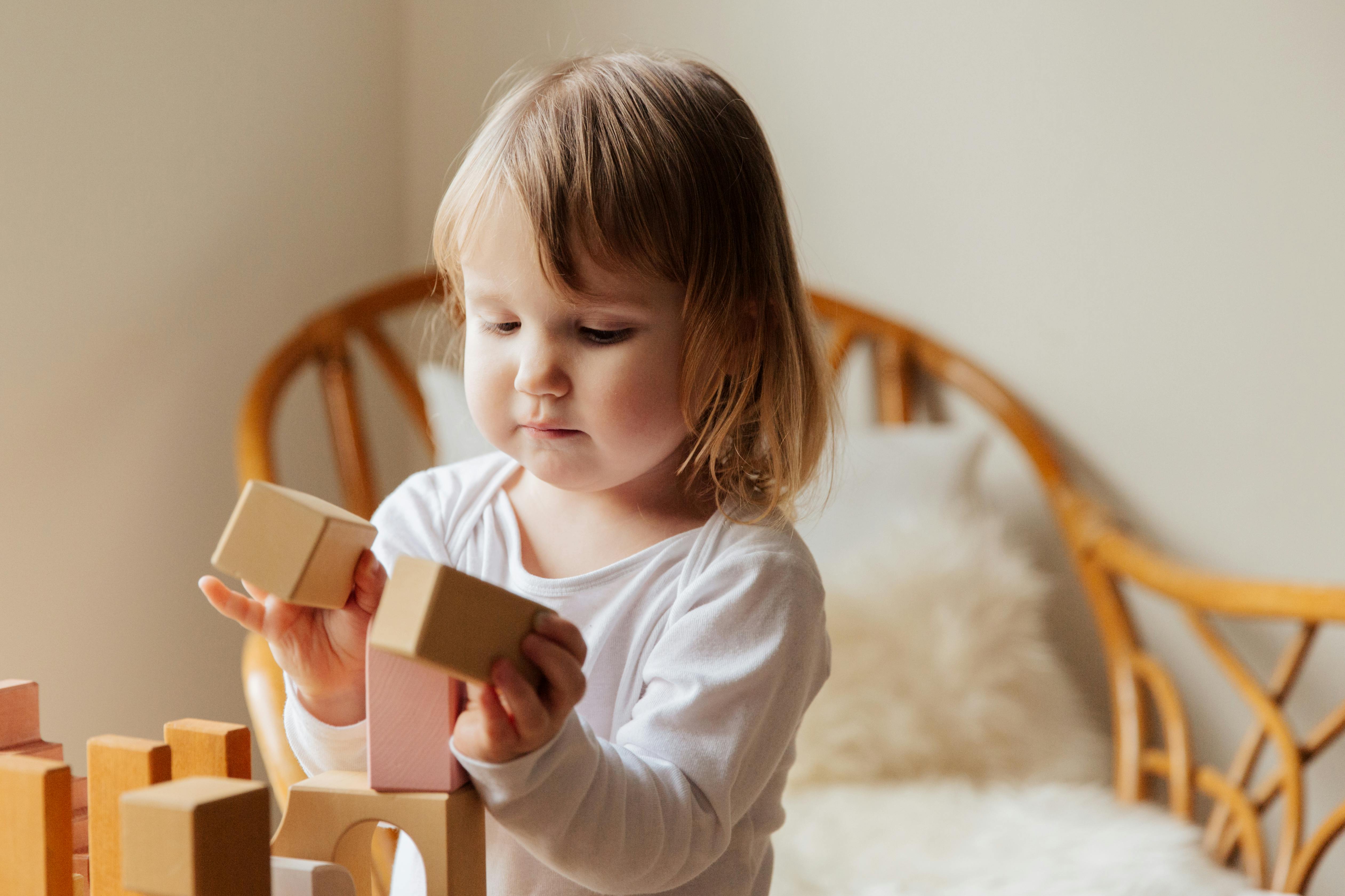 photo of child playing wooden blocks