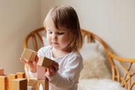 可爱的幼儿在室内与积木互动，展现出纯真与顽皮