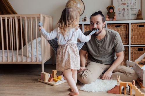 Free A father and daughter share a playful moment together in a cozy indoor setting. Stock Photo