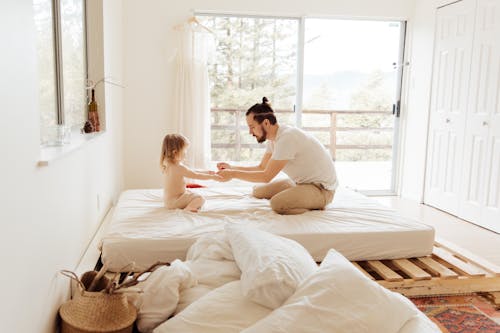 Photo Of People Sitting On Bed