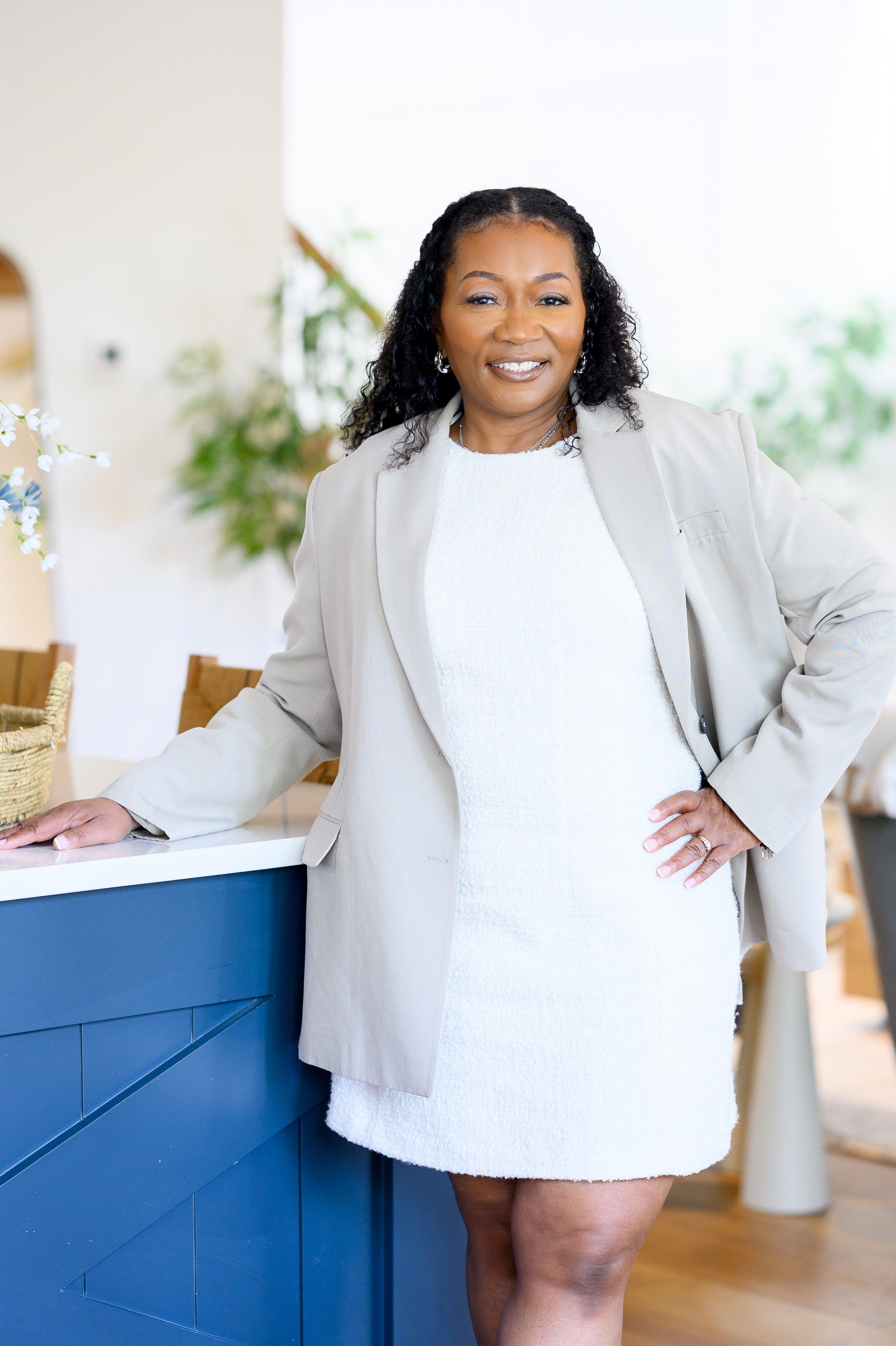 Business woman posing confidently in a stylish beige outfit indoors.