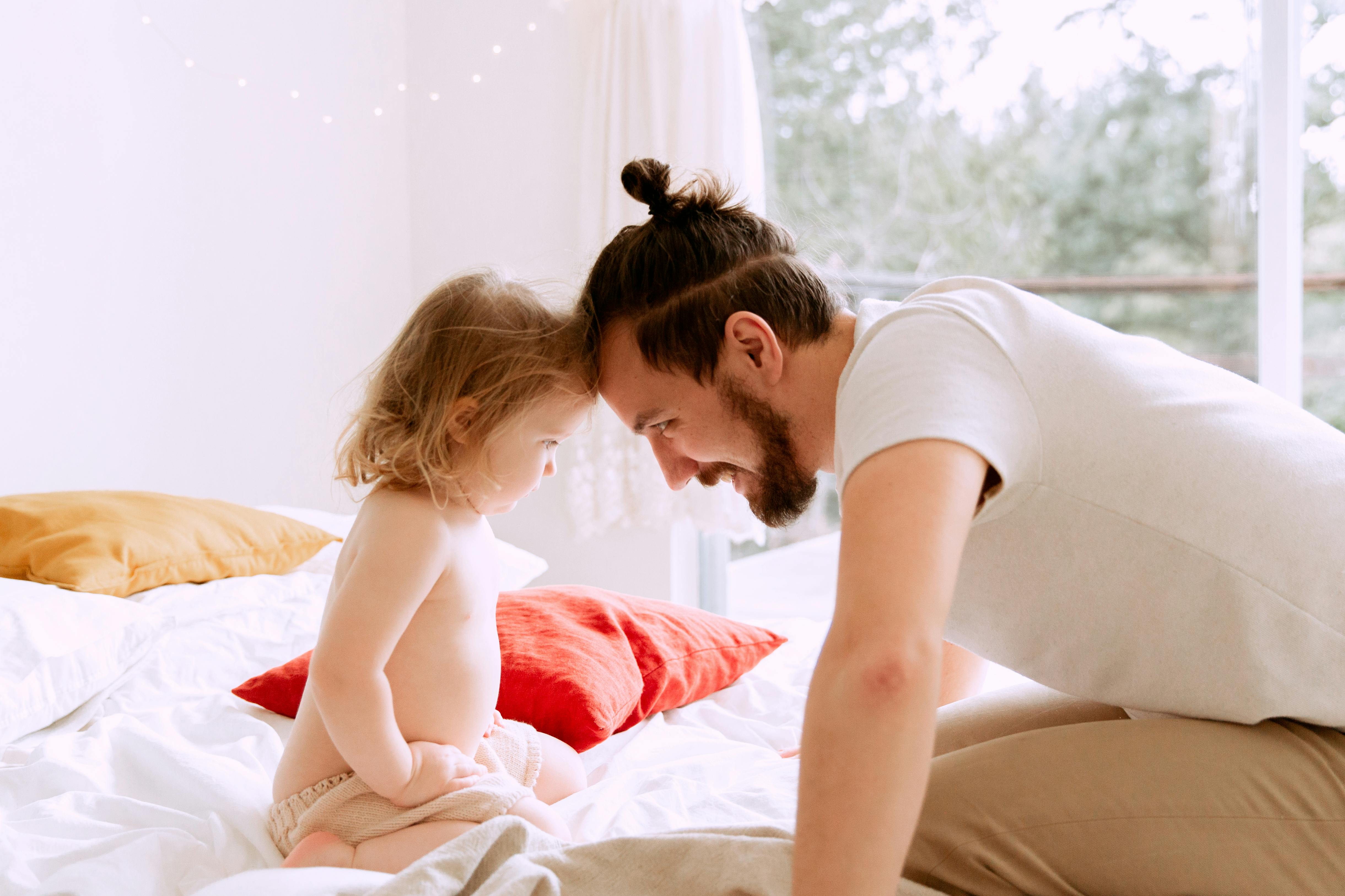 photo of man leaning his forehead on child s forehead