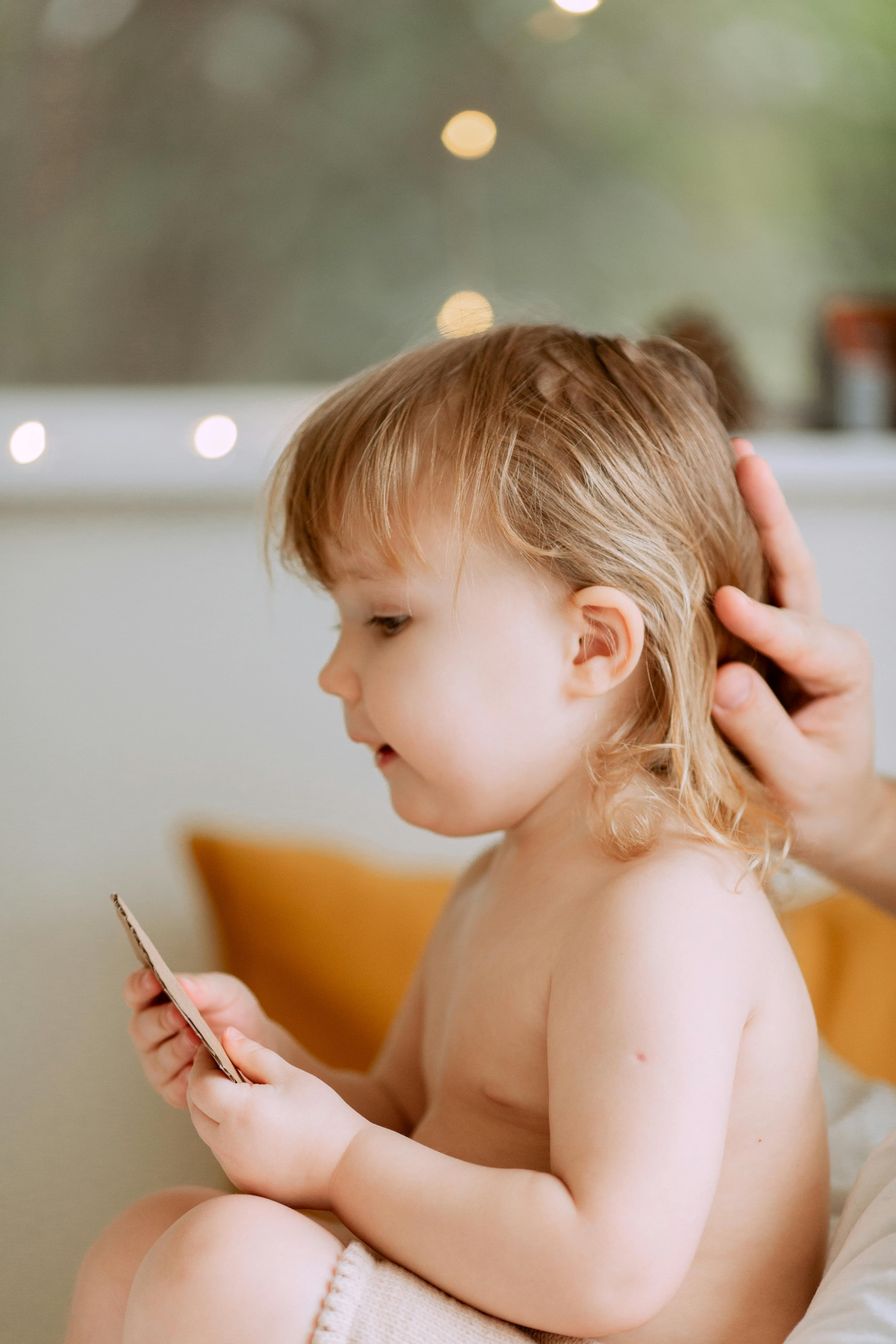 photo of person touching baby s hair