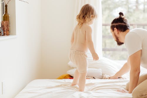 Free A Father Fixing The Bed With Her Child Stock Photo