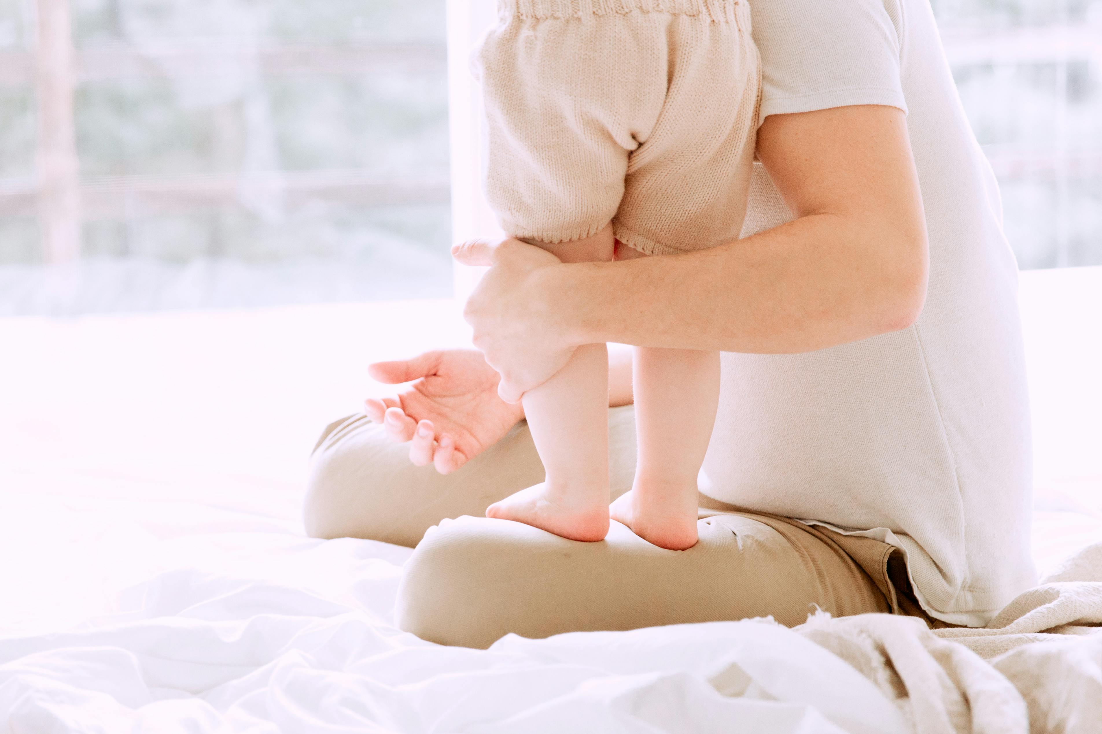 baby standing on her father s lap