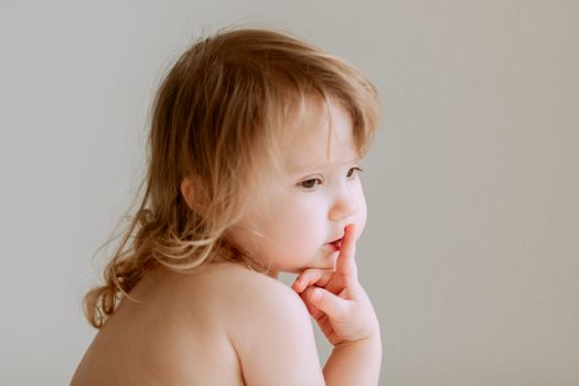 一幅幼儿沉思的迷人肖像，流露出天真与好奇