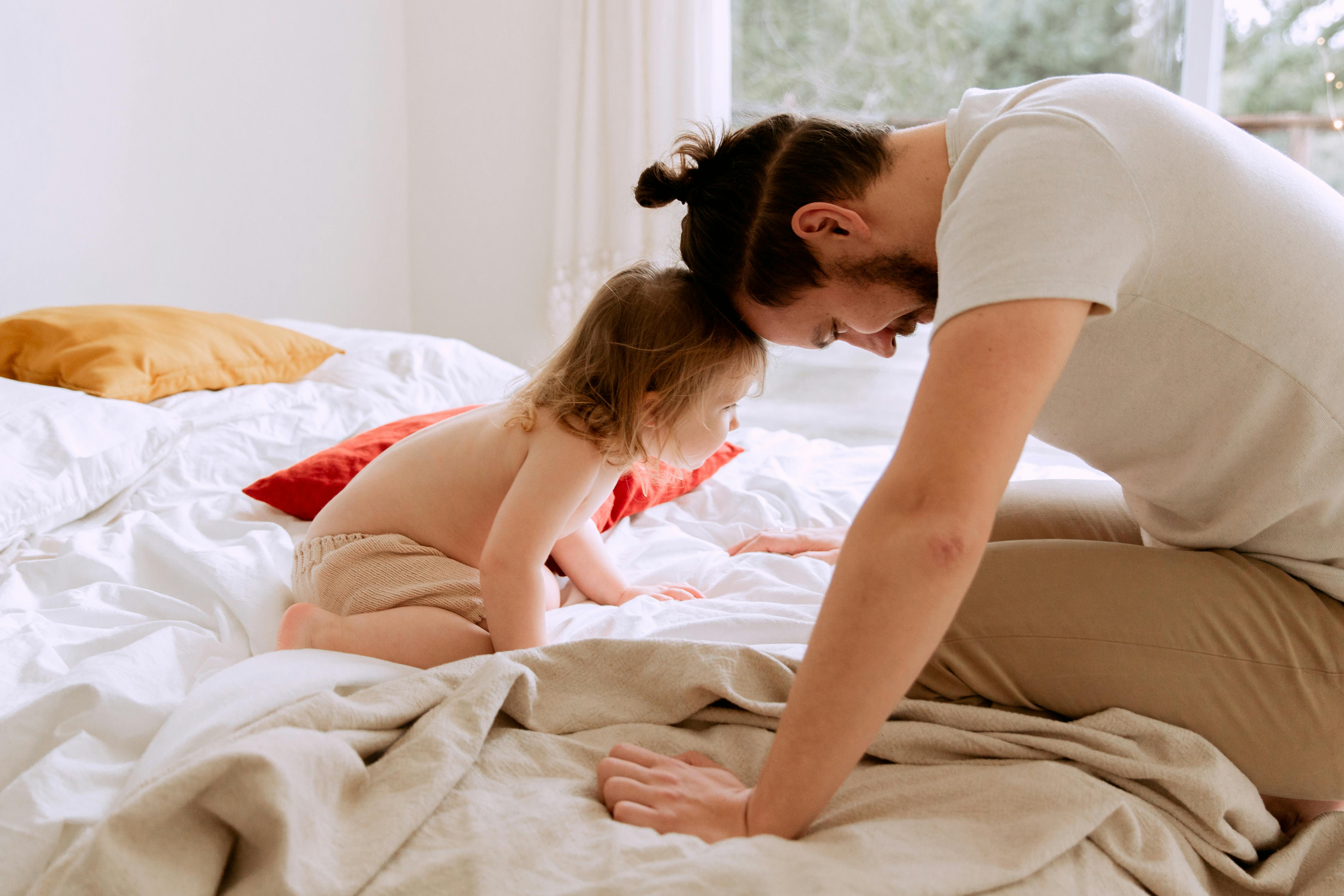 photo of man leaning his head on child