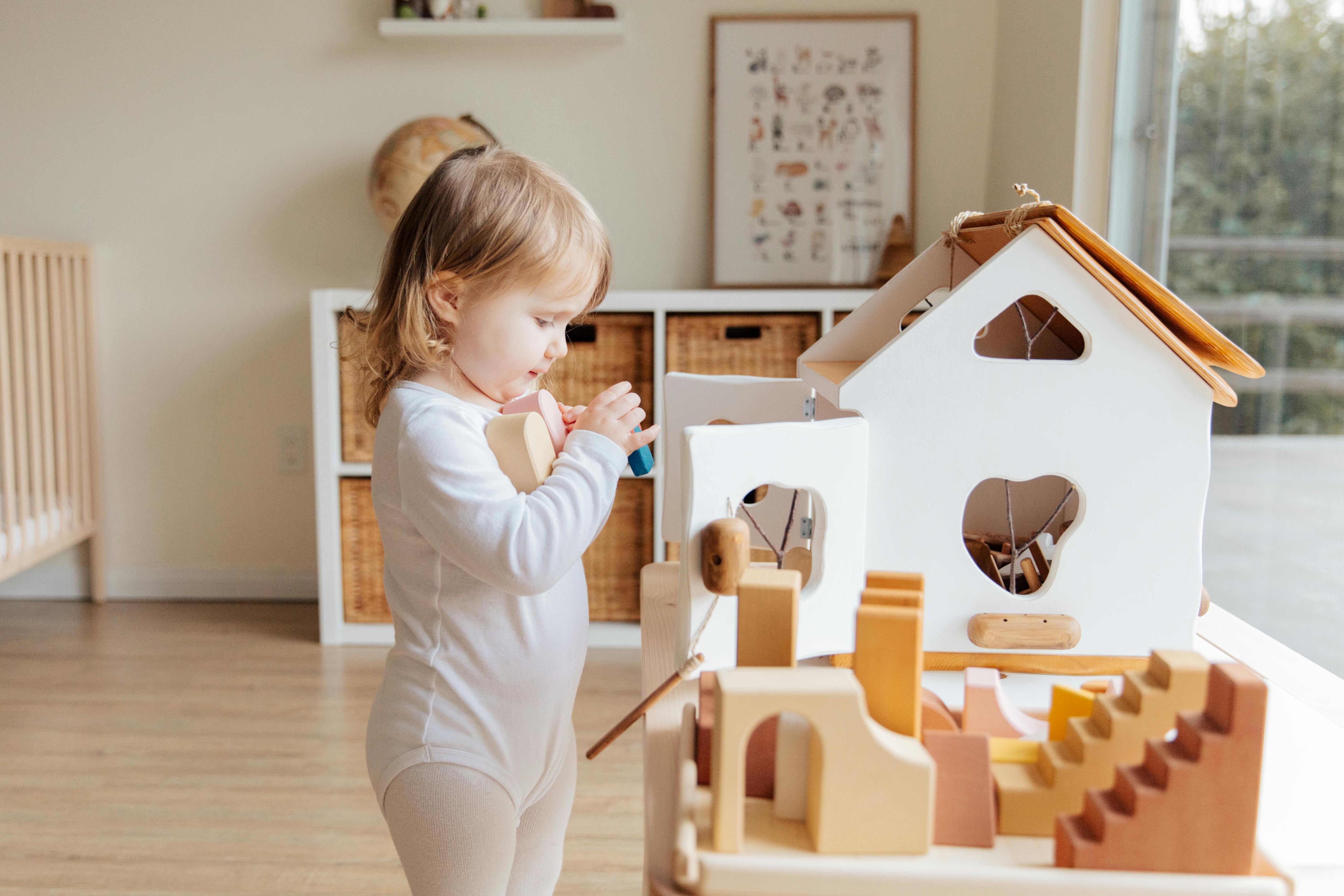 photo of child holding wooden blocks