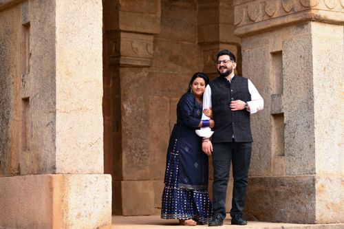 Free Happy couple posing in traditional attire against ancient architecture in Delhi, India. Stock Photo
