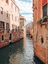 Calm surface of narrow channel among old houses with brick walls located in old town