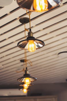 Stylish pendant lights hanging in a modern café with unique ceiling design.