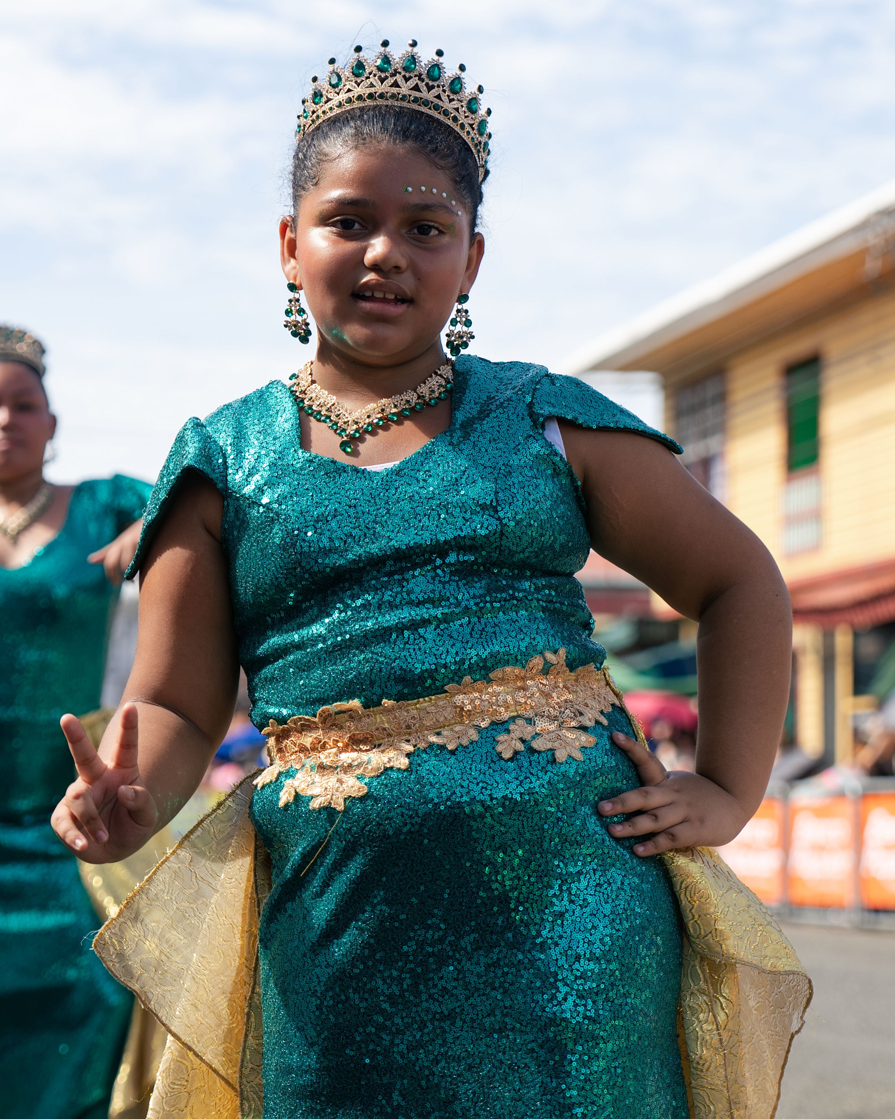 A young girl wearing a vibrant traditional costume participates in a street parade in Limón, Costa Rica.