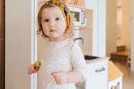 一个可爱的小孩戴着黄色头带，在明亮舒适的房间里玩耍