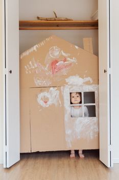 幼儿在室内用纸板房子进行手工制作，在玩耍中展现创造力和想象力