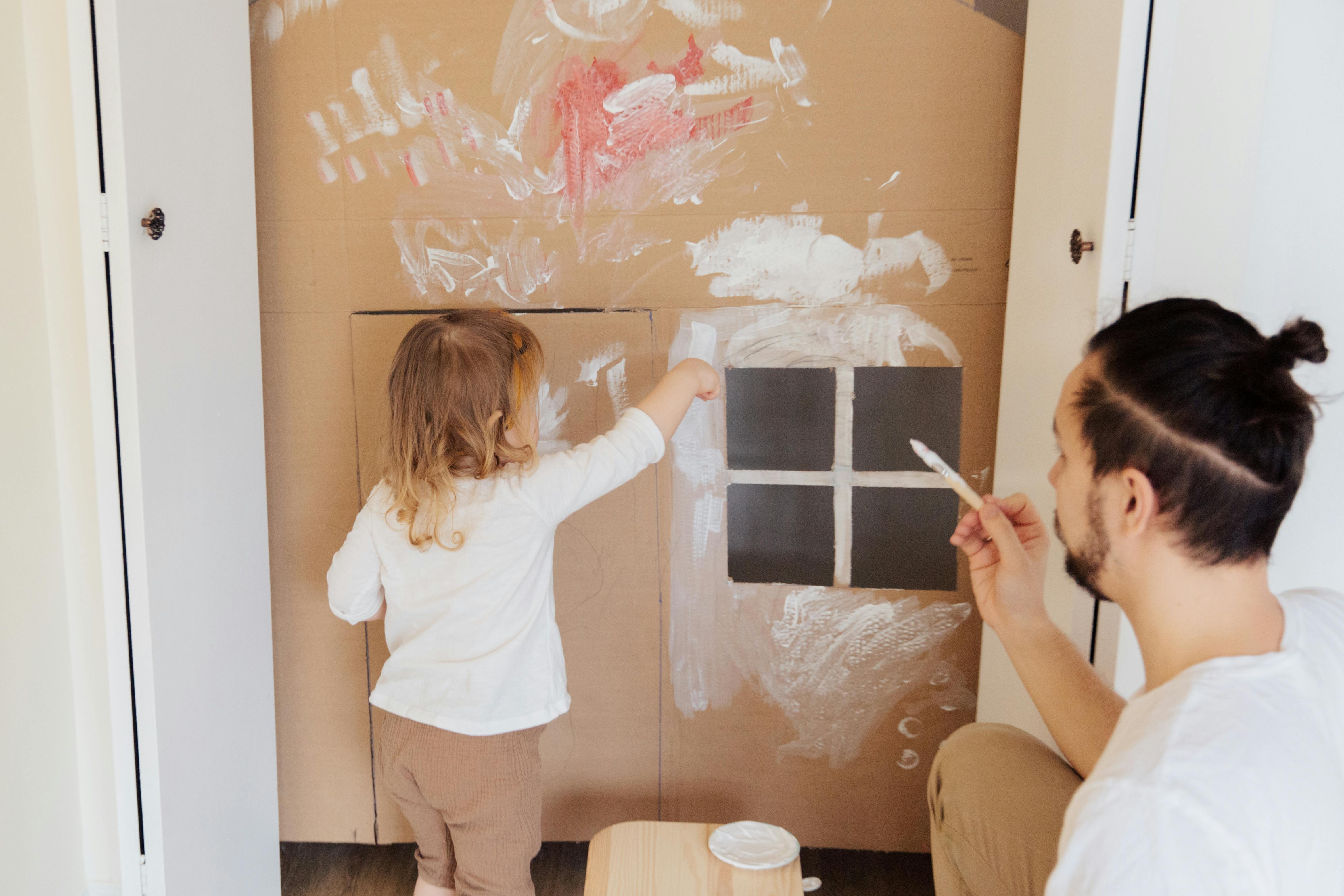 photo of child painting cardboard