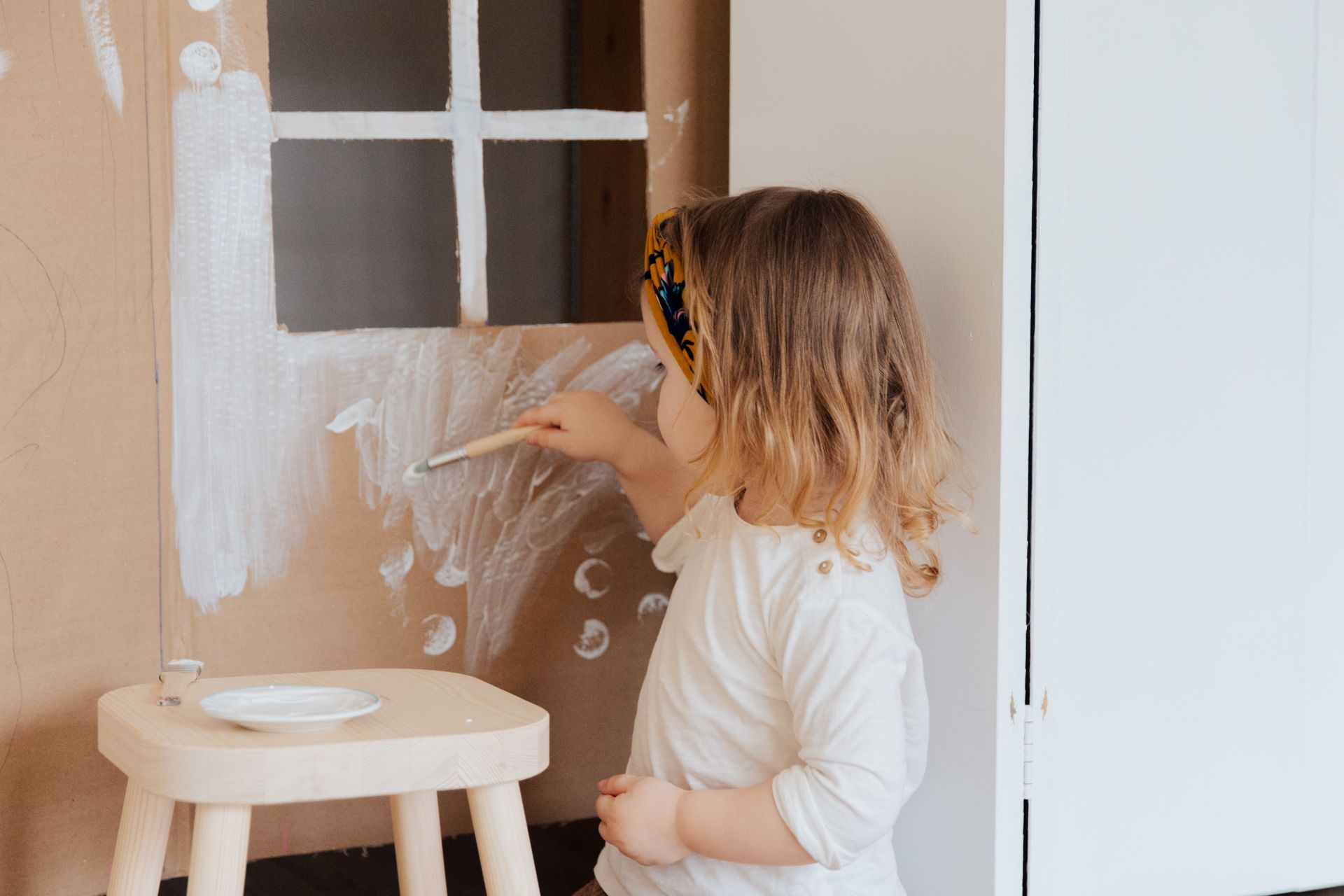 Girl in White Shirt Painting on Cardboard Play House