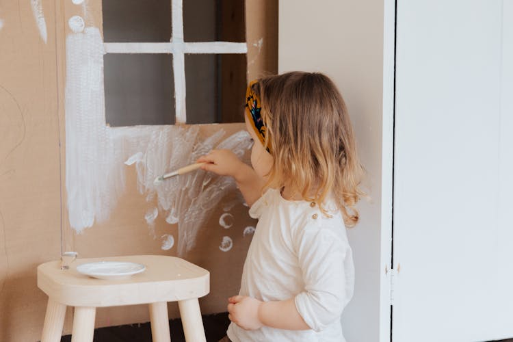 Girl In White Shirt Painting On Cardboard Play House