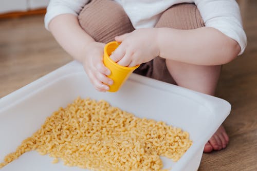 Person Holding Yellow Plastic Container