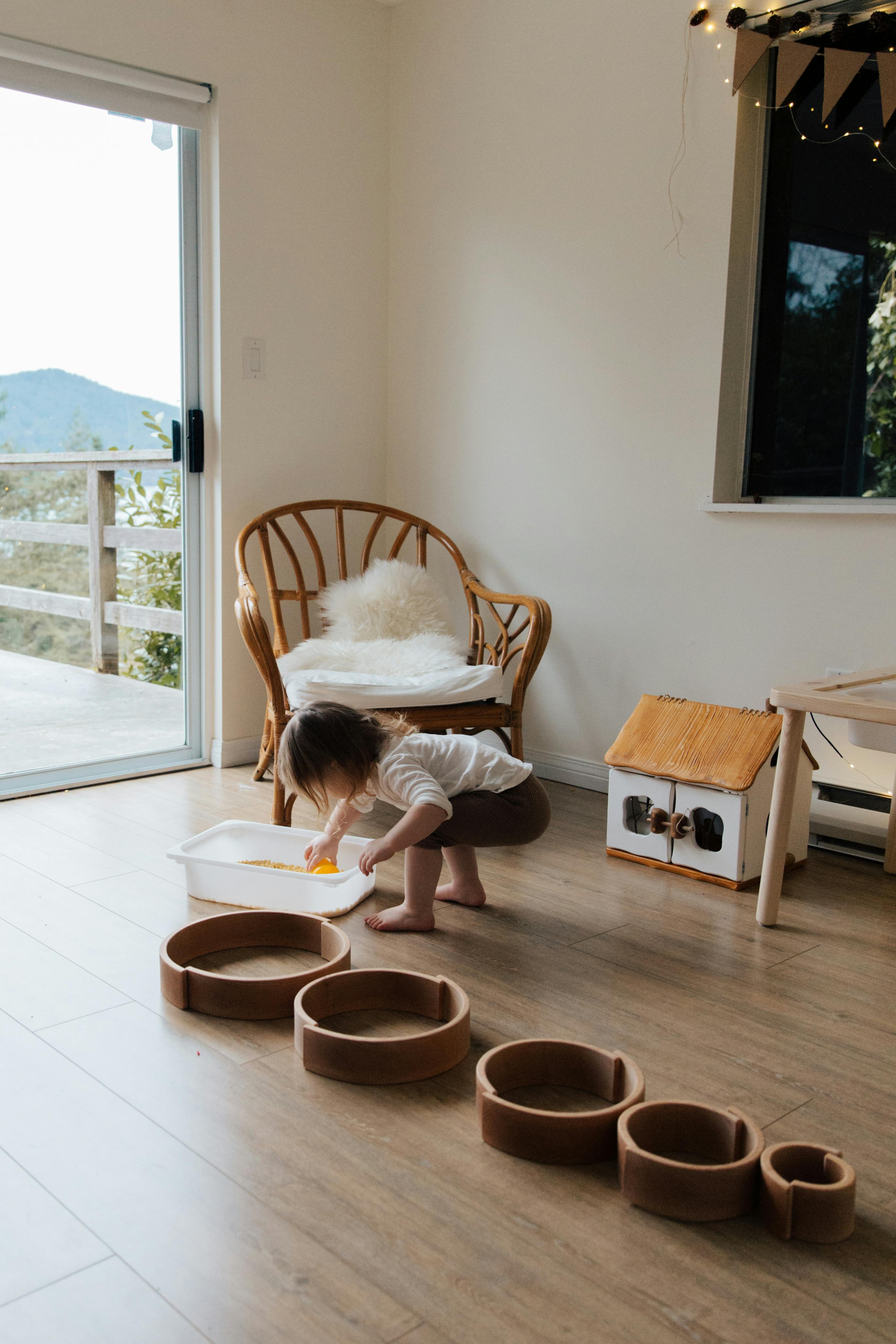 anonymous toddler using white container while developing fine motor skills at home