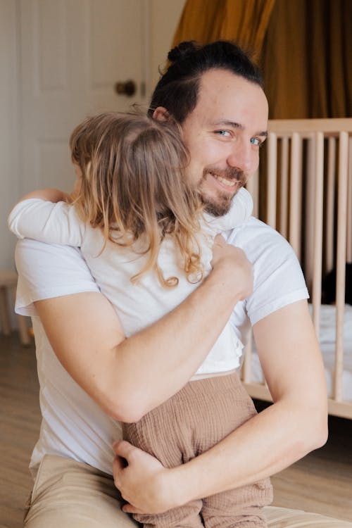 A Smiling Dad Hugging her Little Daughter 