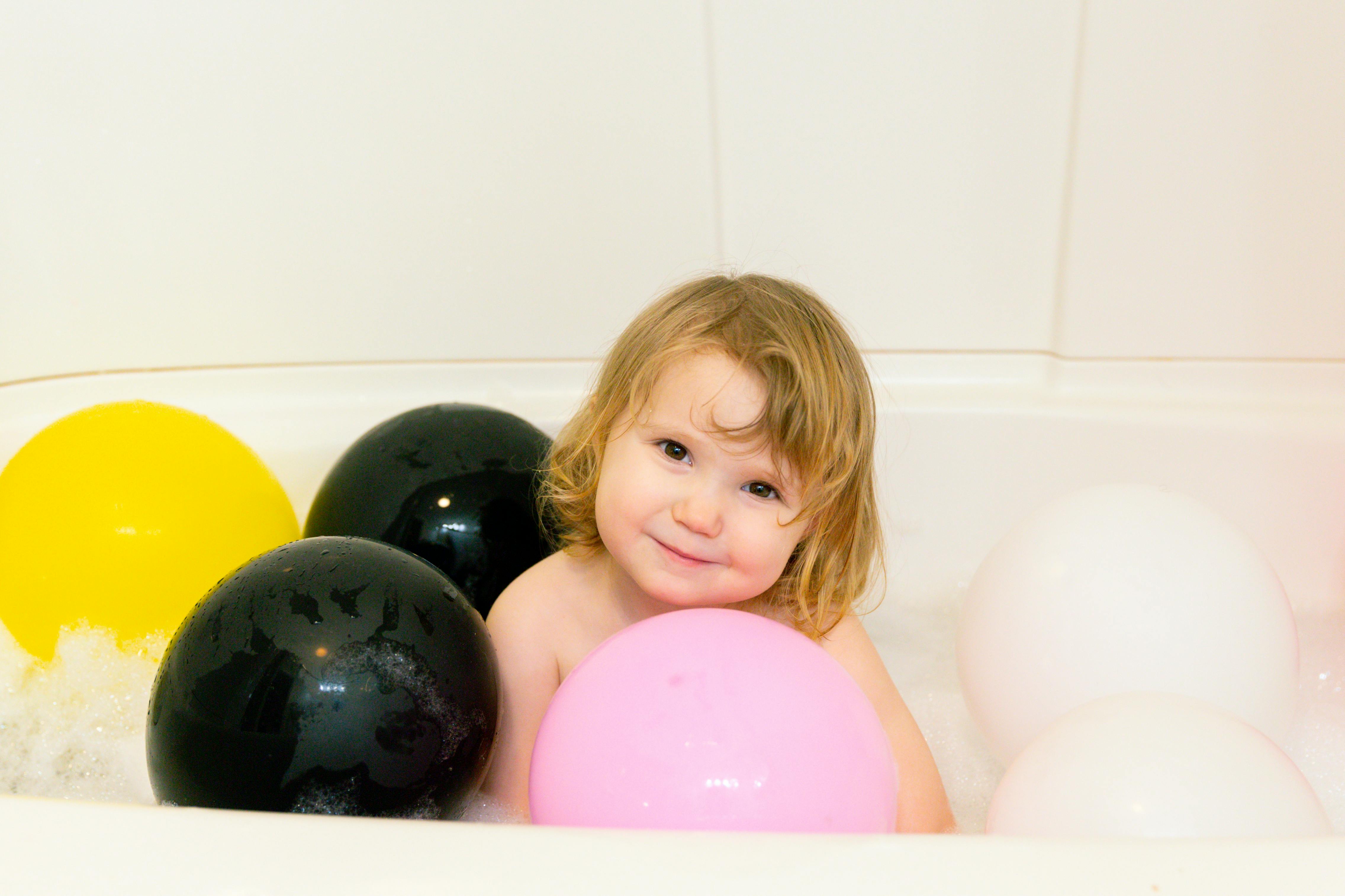 photo of child surrounded by balloons