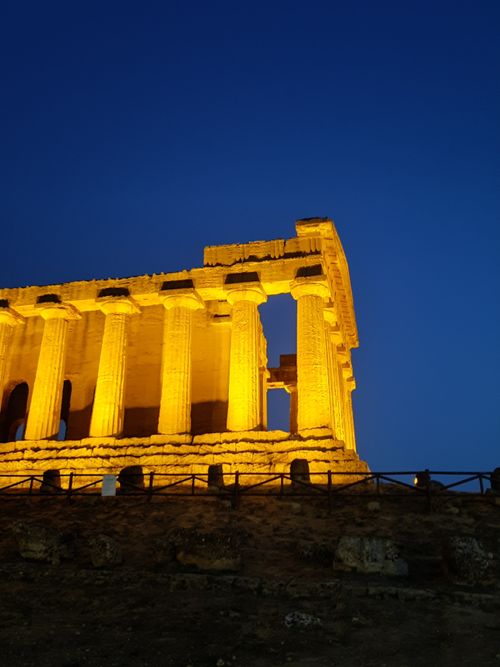 Free A beautifully lit ancient Greek temple with Doric columns against a twilight sky. Stock Photo